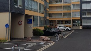 Un immeuble résidentiel à plusieurs étages avec un espace de stationnement à l’avant.