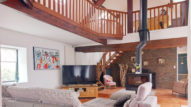 Un salón amplio con un sofá grande, televisor y chimenea.