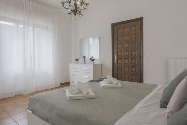 A bedroom with a bed, a dresser, a mirror, and a door. - [MAISON TUSCANY] ★ ★ ★ ★ ★ 20 minutes from Forte dei Marmi | Netflix and comfort (Carrara)