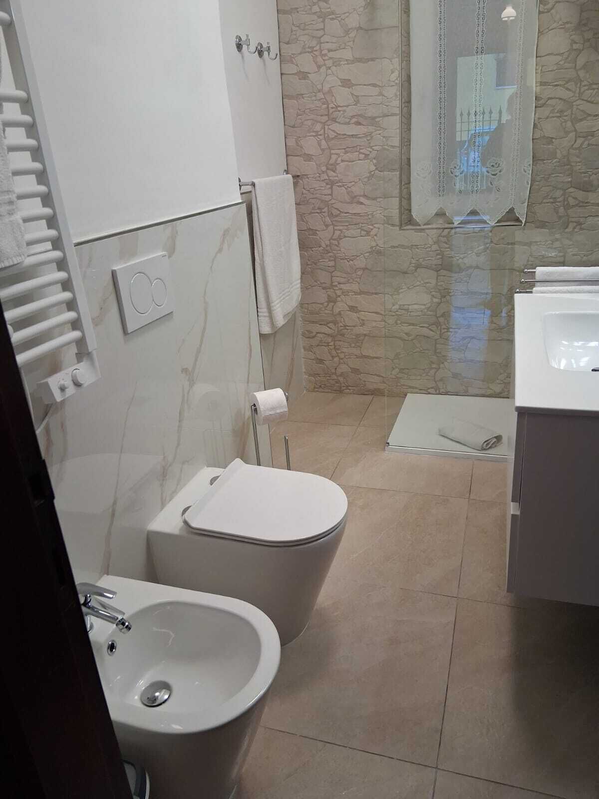 A bathroom with a toilet, bidet, and sink.