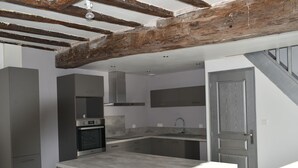 A modern kitchen with a built-in oven, stainless steel cabinets, and a large island with a sink. - Charming Countryside Farmhouse with Garden, Terrace & Spacious Rooms (Avessé)