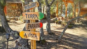 Un panneau indicateur en bois, orné de flèches indiquant les directions vers «SULLUTE», «TERRA», «PARADISI» et «A VISTA».
