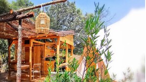 Un chalet en bois rustique doté d’un balcon, entouré de verdure.