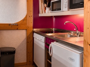 A compact kitchen with a sink, microwave, and dishwasher.