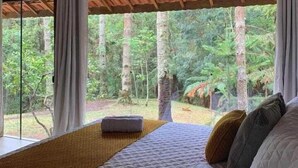 A bedroom with a large bed, wooden ceiling, and a view of a forest through a window. - MD LUAR DA MONTANHA (Camanducaia)