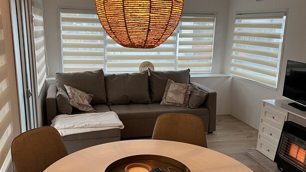 A modern living room with a round dining table, a sofa, and a fireplace. - Chalet Quattro in Bosrijke Omgeving Anloo (Anloo)