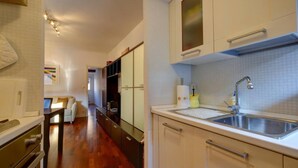 A modern kitchen with a stainless steel sink, wooden cabinets, and a countertop. - LA CASETTA (Venezia)