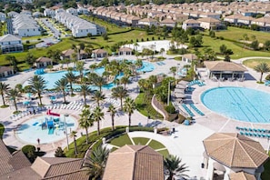 A resort with multiple swimming pools, palm trees, and a well-maintained lawn. - 8986 CC - Champions Gate (Kissimmee)