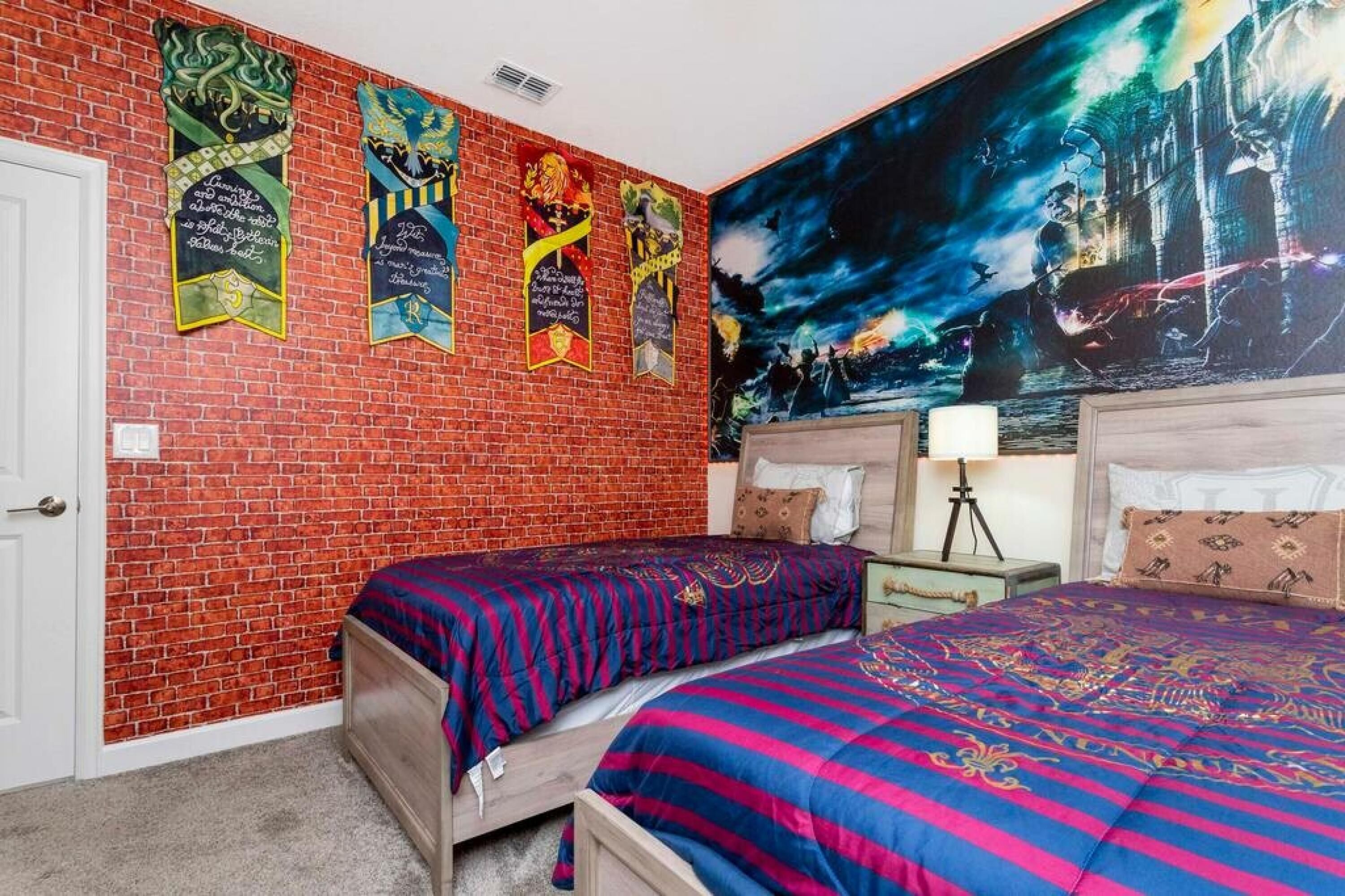 Une chambre avec deux lits, un mur en briques et une grande fresque murale.