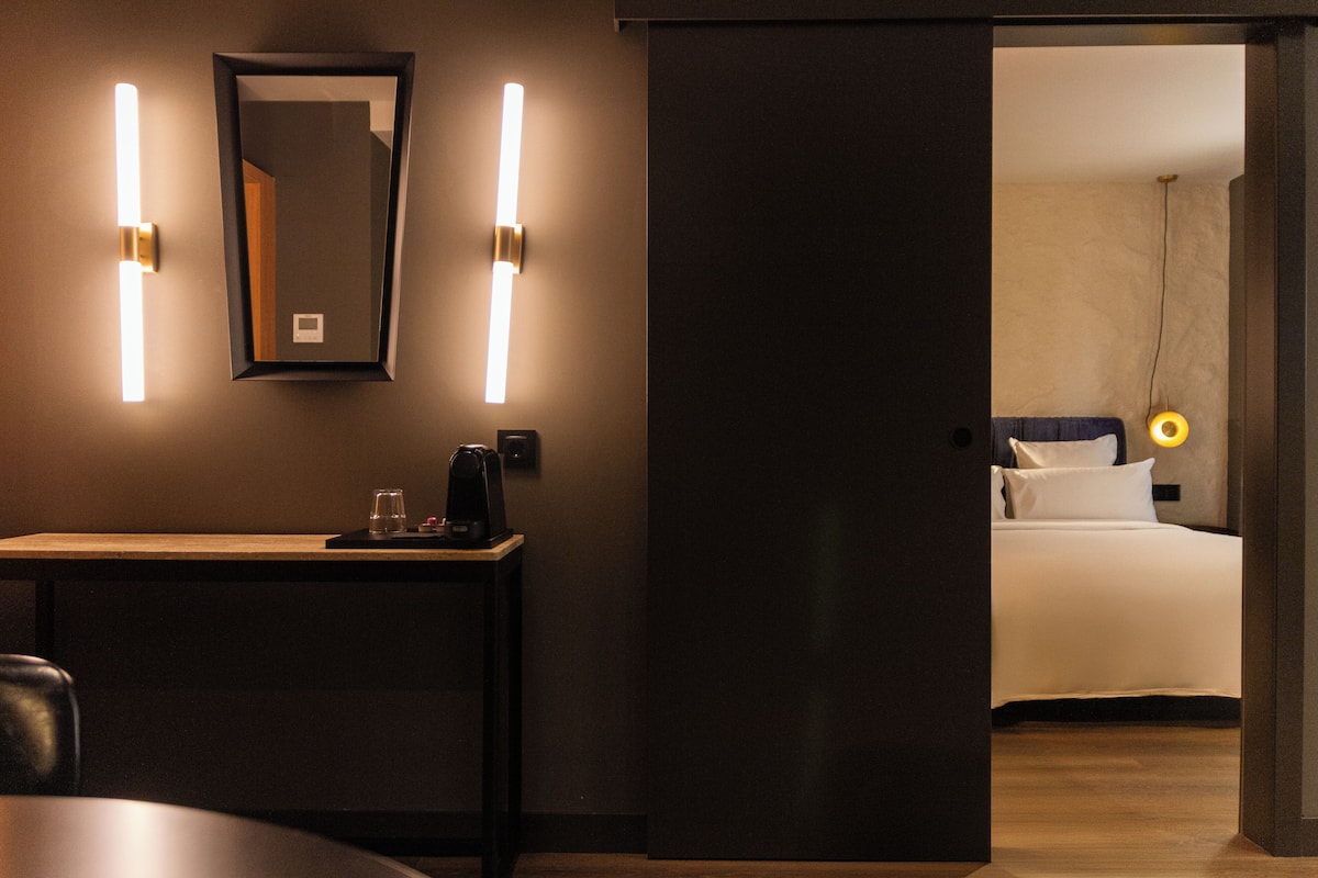 Une chambre d’hôtel équipée d’un bureau, d’un miroir et de lampes de chevet.