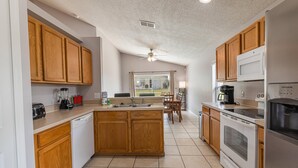 A kitchen with wooden cabinets, a central island, a sink, a stove, and a microwave. - 173 Hillside Dr in Davenport (Davenport)