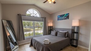 A hotel room with a large bed, a window with curtains, a ceiling fan, and a painting on the wall. - 173 Hillside Dr in Davenport (Davenport)