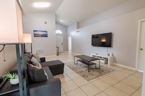 A modern living room with a sofa, coffee table, and TV.
