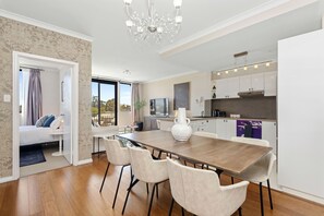 Una cucina moderna con zona pranzo, un vaso bianco di grandi dimensioni e un lampadario.