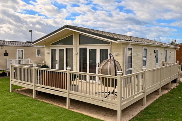 A mobile home with a fenced deck, large windows, and a covered outdoor grill. - Sunset 19 - Southview Holiday Park Skegness (Skegness)