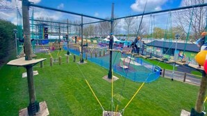 An outdoor adventure park with rope bridges, climbing structures, and a fenced play area. - Sunset 19 - Southview Holiday Park Skegness (Skegness)
