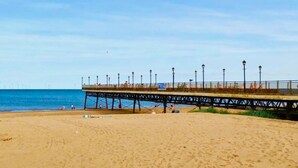 A beach with a pier extending into the water, featuring street lamps and a walkway. - Sunset 19 - Southview Holiday Park Skegness (Skegness)