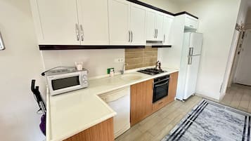 Familie appartement | Privékeuken | Een koelkast met diepvriezer, een kookplaat, een vaatwasser