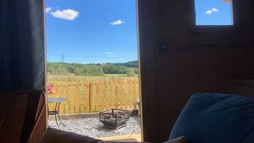 A room with a view of a wooden fence and a grassy field.