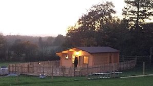 A small brick building with a sloped roof, surrounded by a wooden fence. - Cosy 1-bed Farm Stay Cabin (Chesterfield)