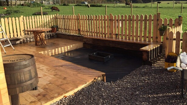 A patio with a wooden deck, a round table, and a seating area. - Cosy 1-bed Farm Stay Cabin (Chesterfield)