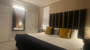 A hotel room with a large bed, a wardrobe, a mirror, and a bedside table. - 1 Bed Flat - Sleeps 2 - Jacuzzi - Parking - Wifi (Birmingham)