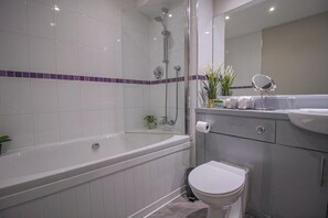 Bañera con ducha, bañera profunda, secador de pelo, toallas