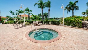 A circular pool with a tiled edge, surrounded by lounge chairs and palm trees. - VVN 5-229 - Vista Verde North - Premium (St. Petersburg)