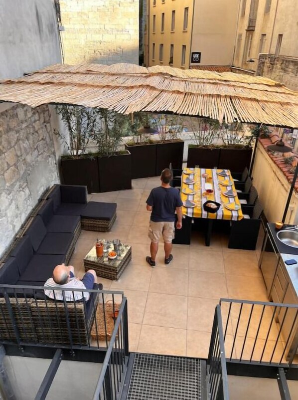 Een terras op het dak, met een eettafel, zitplaatsen en uitzicht over de stad.