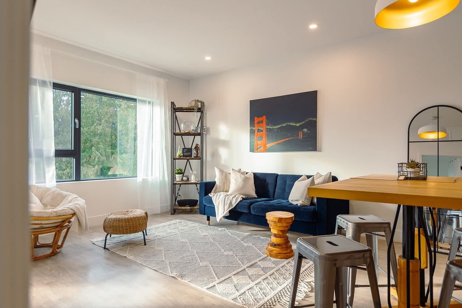 A modern living room with a sofa, a dining table, and a bookshelf.