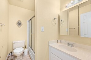 A bathroom with a toilet, sink, and shower.