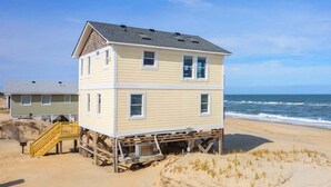 A two-story beach house with a staircase and a view of the ocean. - OCS1 Ocean-Front w/ Panoramic, Water-Front Views (Nags Head)