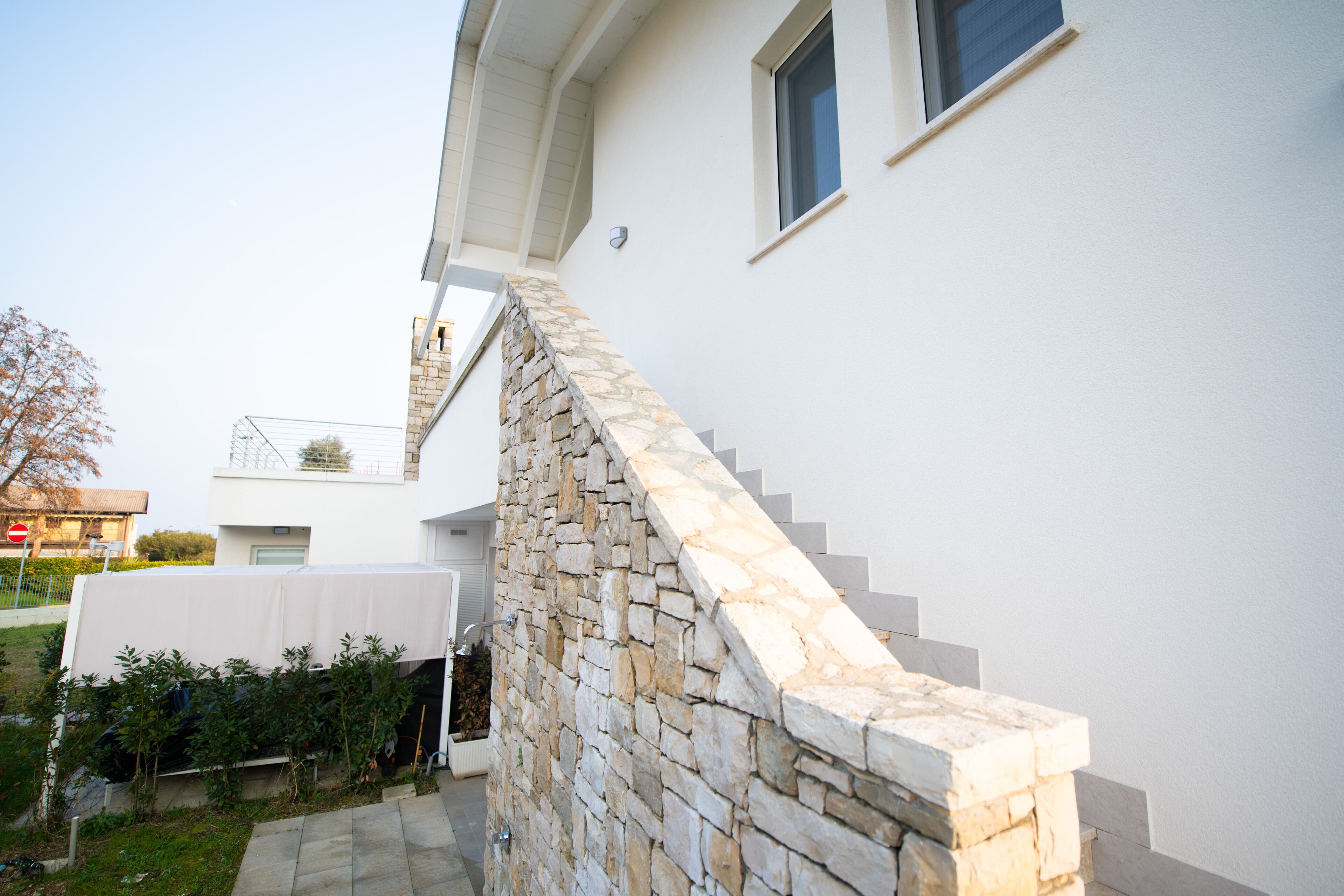 A modern house with a stone staircase leading to a white door.