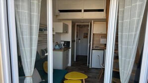 Een compacte keuken met een eetgedeelte, een klein tafeltje en een bank.