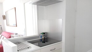 Une salle de bain moderne avec un meuble-lavabo blanc, un miroir et un plan de toilette noir.