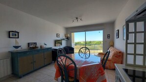 Un comedor con una mesa cubierta por un mantel, un armario y un sofá.