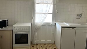 A compact kitchen with a stove, oven, microwave, and sink. - La tranquille - St Hilaire de Riez (SAINT HILAIRE DE RIEZ)