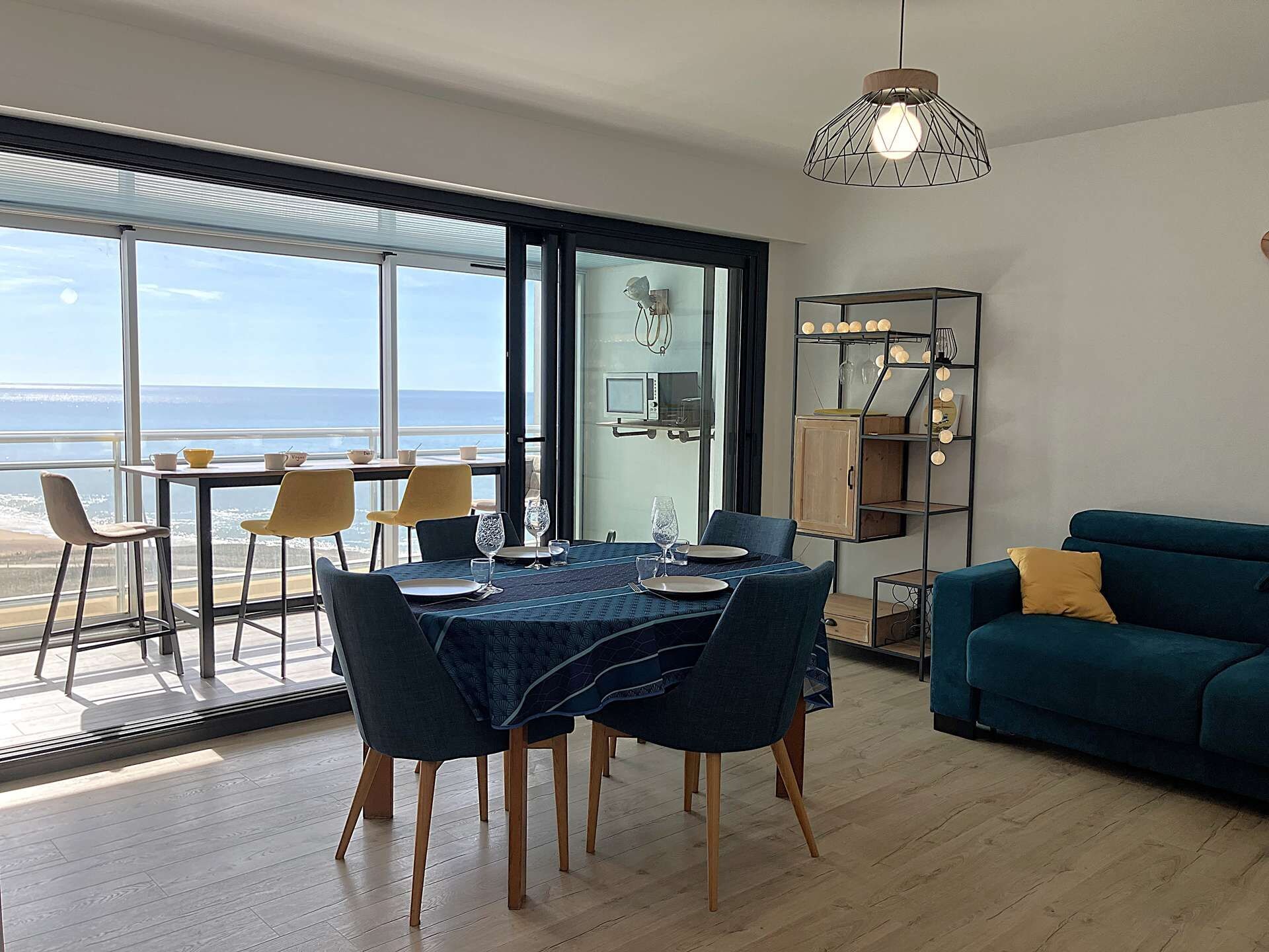 Un espace de vie moderne comprenant un coin repas, un canapé et une vue sur la mer.