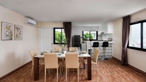 Un apartamento moderno con comedor, cocina y ventanas amplias.