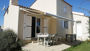 A single-story house with a patio area featuring a table and chairs.