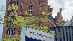 A historic building with a clock tower and a sign reading "King's Cross Square". - 2-bed Apartment Sleeps 7 With Wi-fi (London)