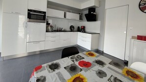 A modern kitchen with white cabinetry, a microwave, and a coffee machine. - La moderna de la pège - Saint hilaire de Riez (SAINT HILAIRE DE RIEZ)