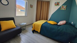 A bedroom with a bed, a sofa, a window, and a curtain. - La moderna de la pège - Saint hilaire de Riez (SAINT HILAIRE DE RIEZ)