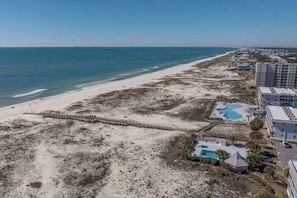 Ein Hotel am Strand mit einer Pier, einem Pool und Blick auf den Strand.