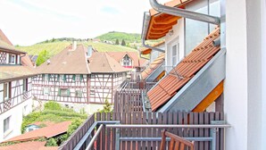 A traditional half-timbered building with a wooden staircase leading to a balcony.