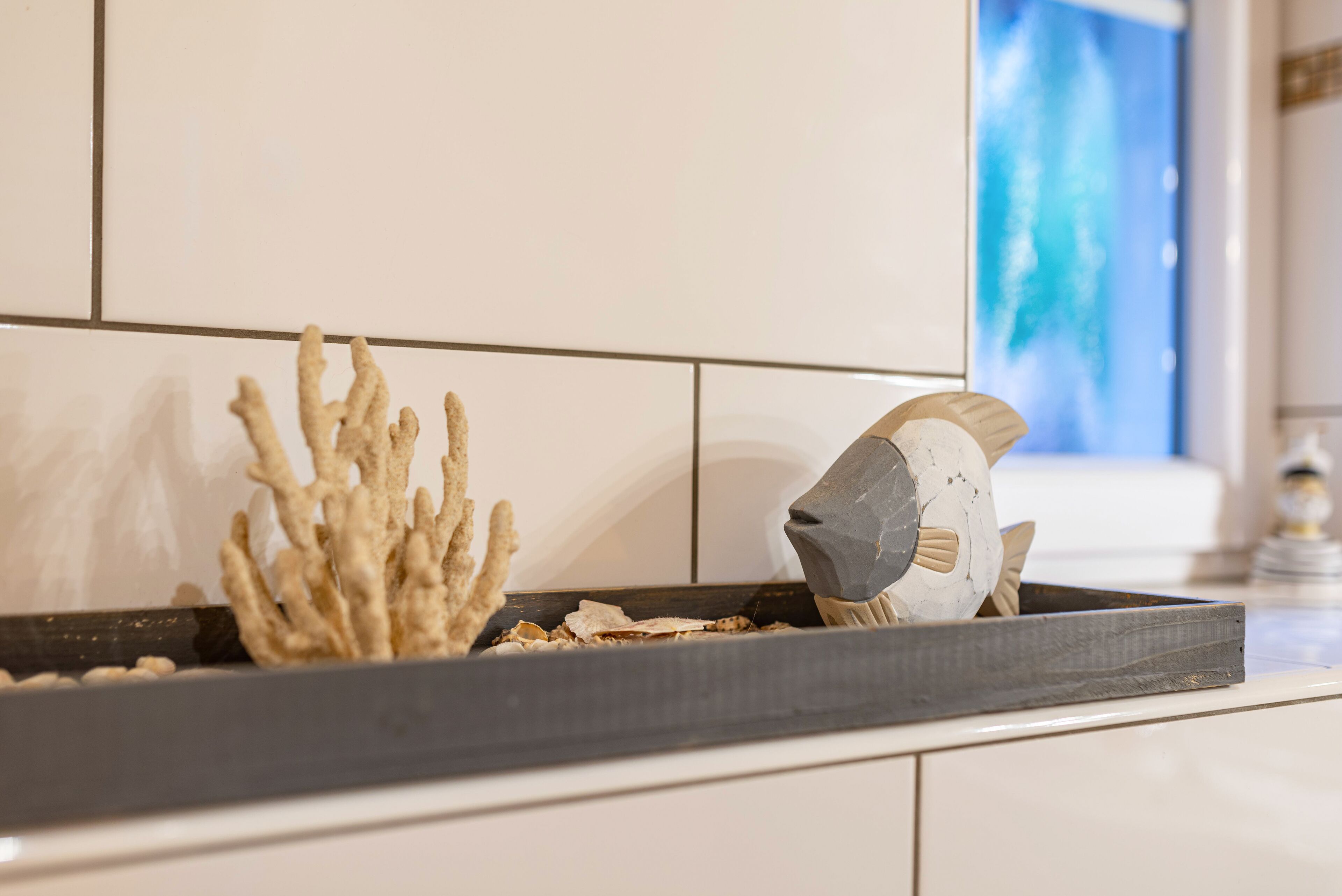 A kitchen counter with a decorative coral piece and a fish sculpture.