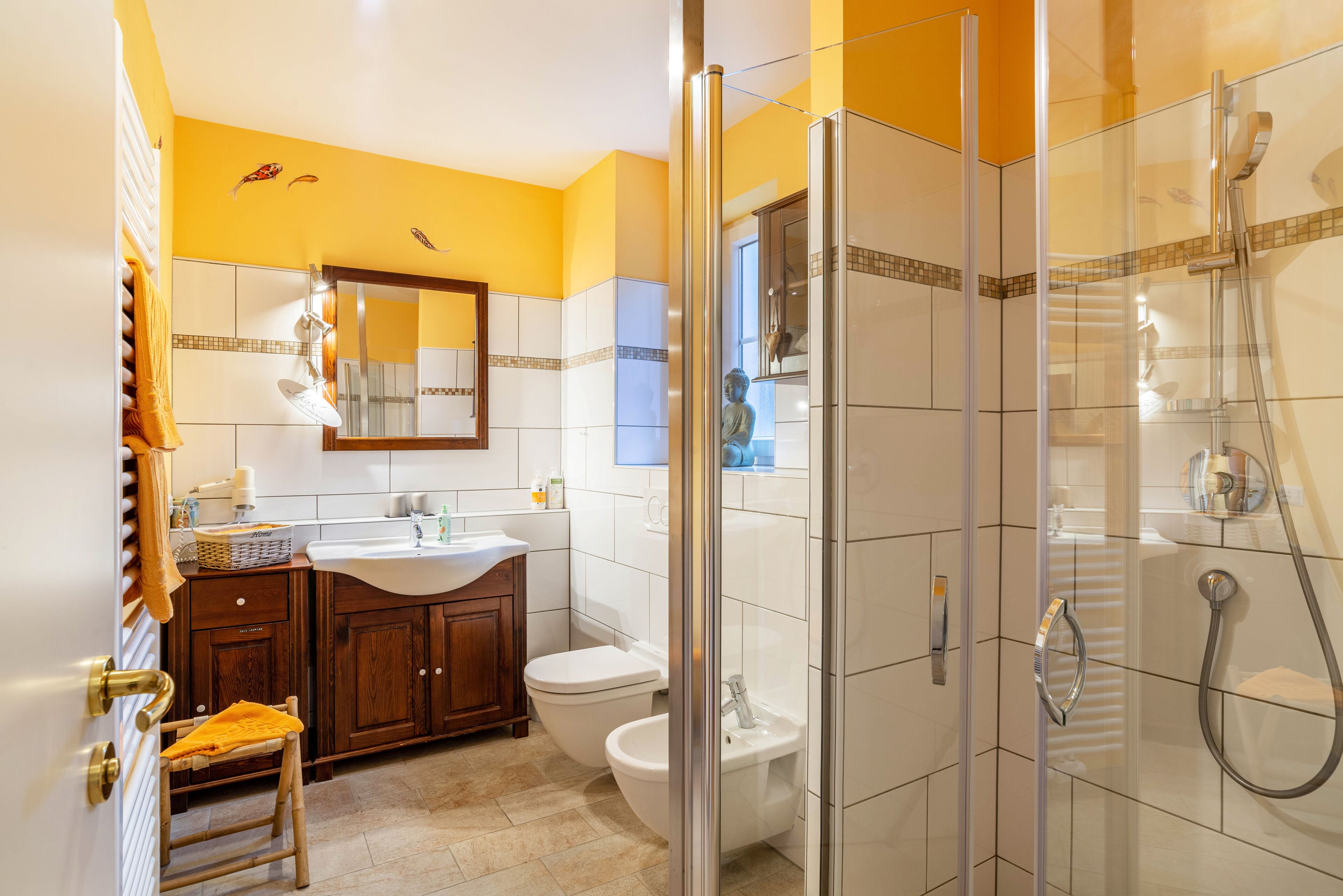 A modern bathroom with a glass-enclosed shower, a wooden vanity, a white sink, and a toilet.