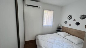 Ein Schlafzimmer mit Bett, Fenster und Wanddekorationen.