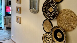A wall with various woven baskets and a mirror.