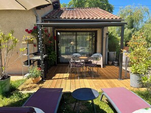 A covered patio with a wooden deck, outdoor furniture, and potted plants. - A natural, cocooning escape just 25 minutes from Bordeaux. (LA LANDE DE FRONSAC)